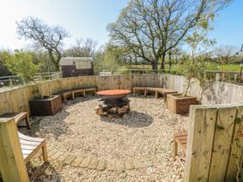 A garden with a circular seating area and a fire pit at Ivy Cottage in Oldwalls, Llanrhidian, Gower