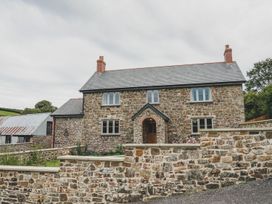 A house with a stone facade and a brick wall at Knowle House Okehampton