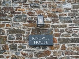 A wall with a nameplate and light fixture at Knowle House Okehampton