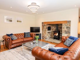 A living room with leather sofas and a fireplace at Knowle House in Okehampton