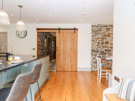 A kitchen with a wooden door and stone wall at Knowle House in Okehampton