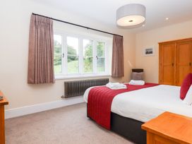 A bedroom with a bed and windows at Knowle House in Okehampton