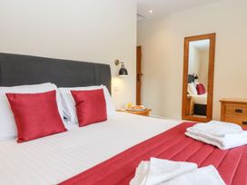 A bedroom with a bed and mirror at Knowle House Okehampton