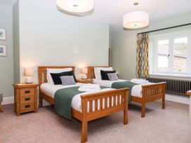 A bedroom with two single beds and a window at Knowle House in Okehampton