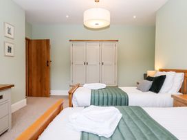 A bedroom with two beds and a wardrobe at Knowle House in Okehampton