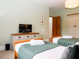 A bedroom with two beds and a television at Knowle House Okehampton
