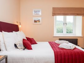 A bedroom with a bed and window at Knowle House in Okehampton