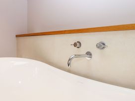 A bathtub with faucets and knobs at Knowle House in Okehampton