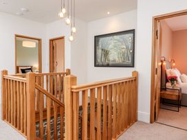A hallway with a wooden staircase at Knowle House Okehampton