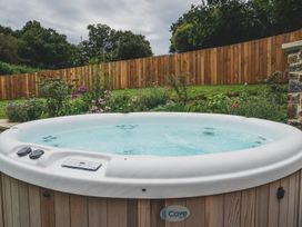 A hot tub with water in a garden at Knowle House in Okehampton