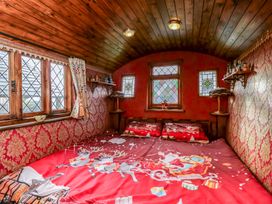 A bedroom with a bed and decorative windows at The Gypsy Caravan in Marlborough