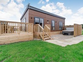 A house with a wooden deck and hot tub at Pear Tree Spa near Thirsk
