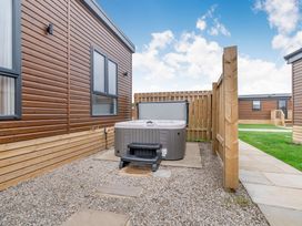 An outdoor area with a hot tub and pathway at Pear Tree Spa (Pet) Carlton Miniott near Thirsk