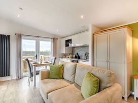 A living room with a sofa and dining area at Pear Tree Spa (Pet) Carlton Miniott near Thirsk