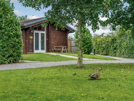 A log cabin with a picnic table in front at Yew Tree Spa (Pet) Carlton Miniott near Thirsk