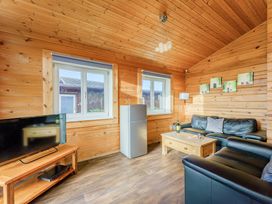 A living room with a fridge and a tv at Yew Tree Spa (Pet) Carlton Miniott near Thirsk