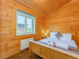 A bedroom with wooden walls and a bed at Yew Tree Spa (Pet) Carlton Miniott near Thirsk
