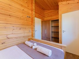 A bedroom with a bed and wardrobe at Yew Tree Spa (Pet) Carlton Miniott near Thirsk