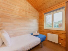 A bedroom with a bed and window at Yew Tree Spa (Pet) in Carlton Miniott near Thirsk