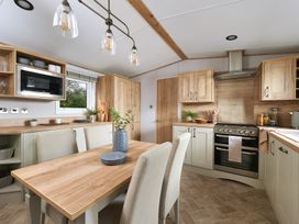 A kitchen with dining table and chairs at Juniper Waterside Spa Carlton Miniott near Thirsk