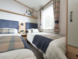 A bedroom with two single beds at Juniper Waterside Spa Carlton Miniott near Thirsk