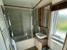 A bathroom featuring a shower, bathtub, sink, and toilet at Acacia Waterside Spa Carlton Miniott near Thirsk