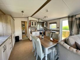A kitchen with dining table and chairs at Acacia Waterside Spa Carlton Miniott near Thirsk