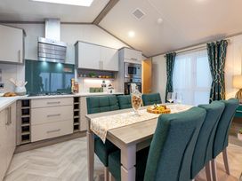 A kitchen with modern appliances and a dining table at Rowan Waterside Spa Carlton Miniott near Thirsk