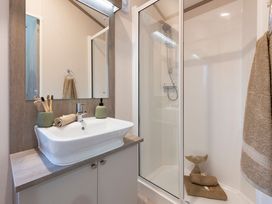 A bathroom featuring a sink and shower at Rowan Waterside Spa in Carlton Miniott near Thirsk