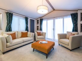 A living room with couches and a coffee table at Rowan Waterside Spa Carlton Miniott near Thirsk