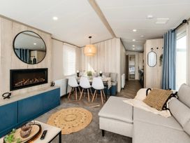 A living room with a couch and dining table at Rowan Waterside Spa Carlton Miniott near Thirsk