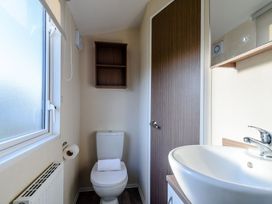 A bathroom with a toilet and sink at Alder Spa Carlton Miniott near Thirsk