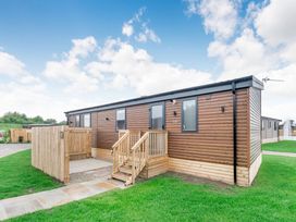A wooden lodge with stairs and a fence in Cedar Carlton Miniott near Thirsk