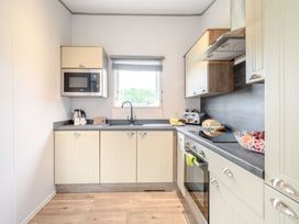 A kitchen with countertop appliances and cabinet storage at Cedar in Carlton Miniott near Thirsk