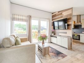 A living room with a sofa and television at Cedar in Carlton Miniott near Thirsk