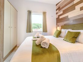 A bedroom with a bed and wardrobe at Cedar in Carlton Miniott near Thirsk