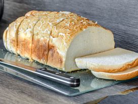 Sliced bread on a cutting board with a knife at Cedar in Carlton Miniott near Thirsk