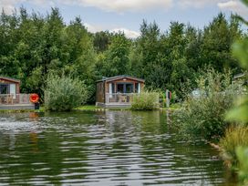 An outdoor area with cabins near water at Spruce Waterside Spa Carlton Miniott near Thirsk