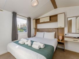 A bedroom with a bed and window at Spruce Waterside Spa, Carlton Miniott near Thirsk
