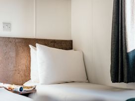 A bedroom with a bed and pillows at Spruce Waterside Spa Carlton Miniott near Thirsk