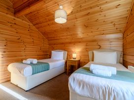 A bedroom with two single beds and a nightstand at Birch Spa Carlton Miniott near Thirsk