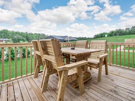 A patio with a table and chairs at Cedar Spa Carlton Miniott near Thirsk