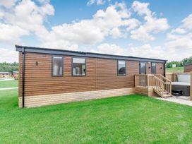 A modular home with a wooden deck outside at Cedar Spa Carlton Miniott near Thirsk