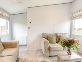 A living room with a couch and a table at Cedar Spa in Carlton Miniott near Thirsk