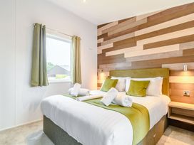 A bedroom with a bed and curtains at Cedar Spa in Carlton Miniott near Thirsk