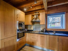 A kitchen with wooden cabinets and appliances at Birch Spa (Pet) Carlton Miniott near Thirsk