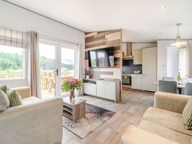 A living room with a sofa, coffee table and television at Cedar Spa (Pet) Carlton Miniott near Thirsk