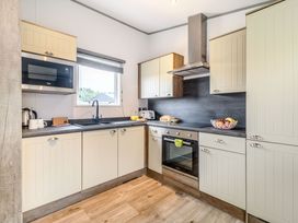 A kitchen with cabinets and appliances at Cedar Spa (Pet) Carlton Miniott near Thirsk