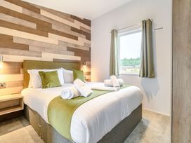 A bedroom with a bed and curtains at Cedar Spa (Pet) Carlton Miniott near Thirsk