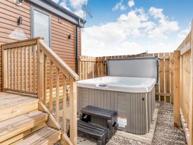An outdoor area with a hot tub and steps at Kinder Spa (Pet) Carlton Miniott near Thirsk